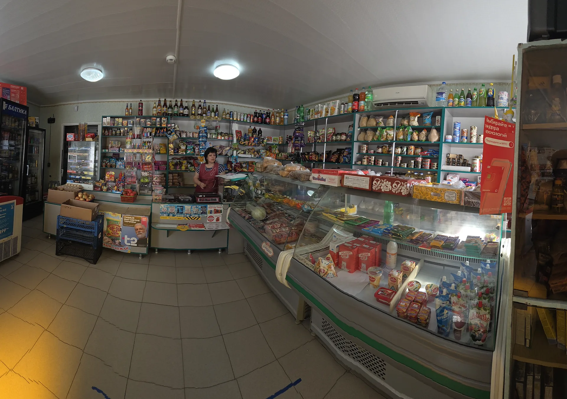 Торговый зал магазина «Тропик» с холодильниками и полками продуктов